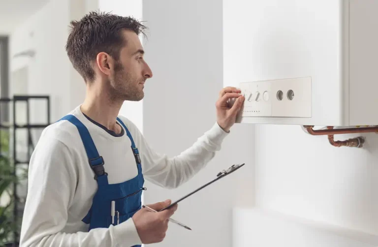 A commercial gas engineer adjusting settings on a boiler.
