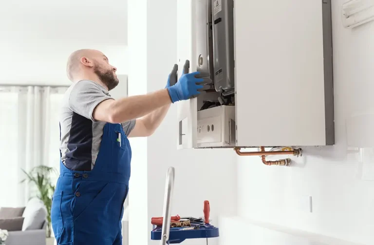 A commercial gas engineer servicing a gas appliance on the wall