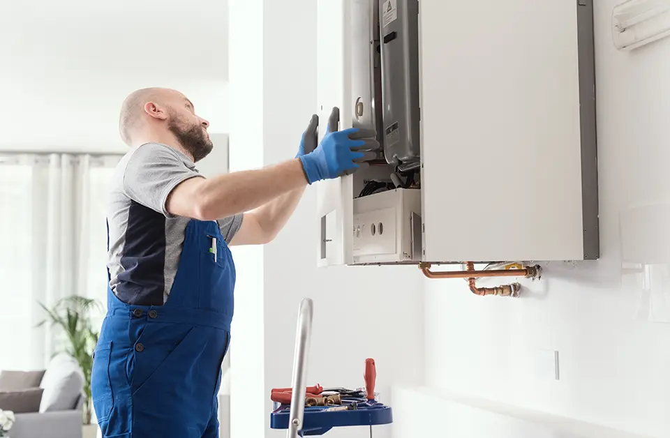 A commercial gas engineer servicing a gas appliance on the wall
