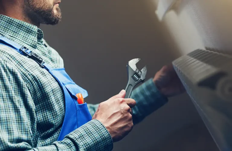 Commercial gas engineer using a wrench in a kitchen setting