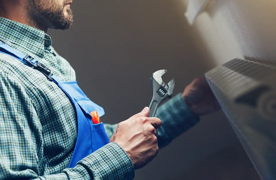 Commercial gas engineer using a wrench in a kitchen setting