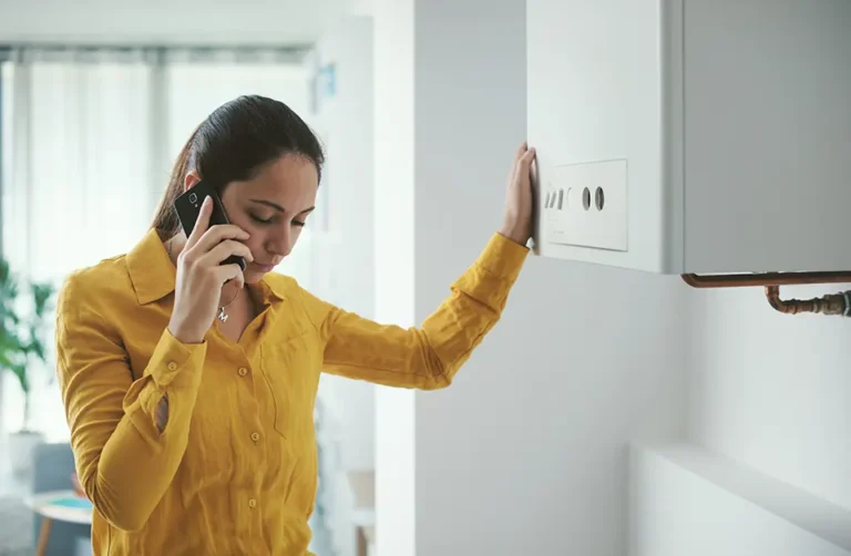 Commercial gas engineer speaking on the phone near gas boiler