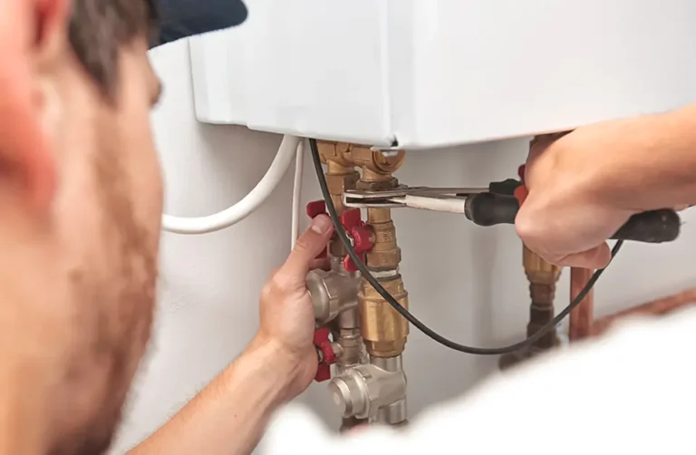 A commercial gas engineer repairing pipework with tools.