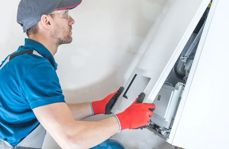 Commercial gas engineer servicing gas equipment with gloves.