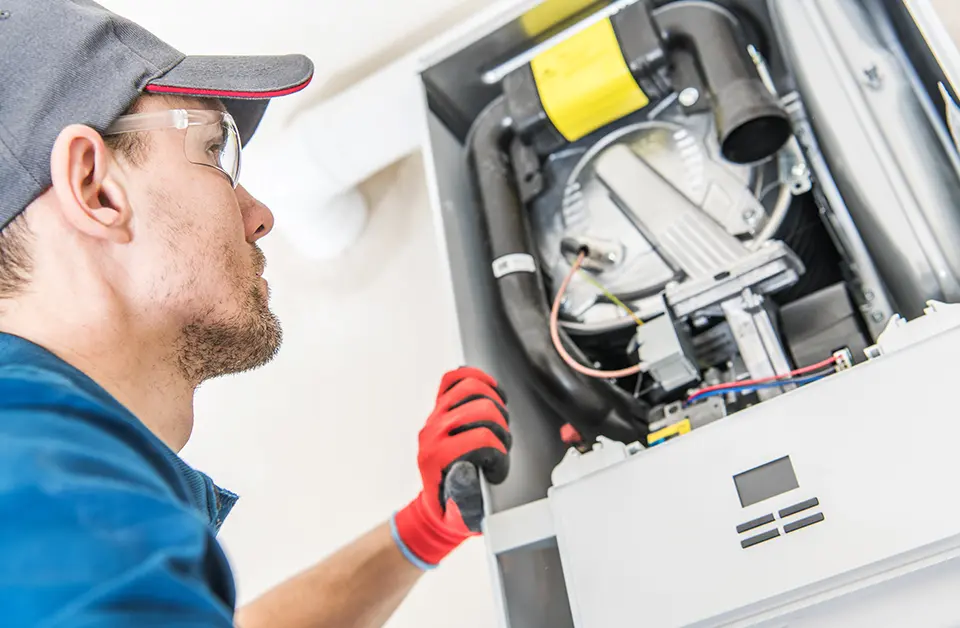 Gas engineer examining a gas appliance in a commercial setting