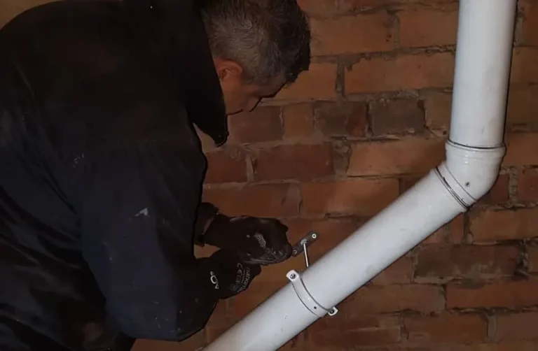 Fitting flue clamps on a vertical boiler flue. Bucknall, Staffordshire