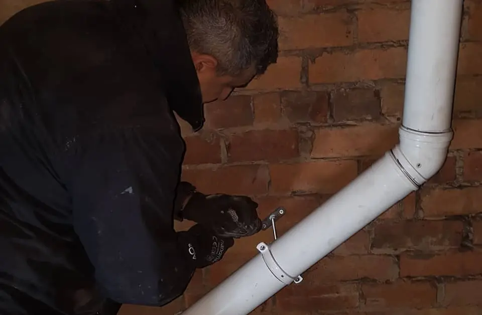Commercial gas engineer servicing pipework in a facility