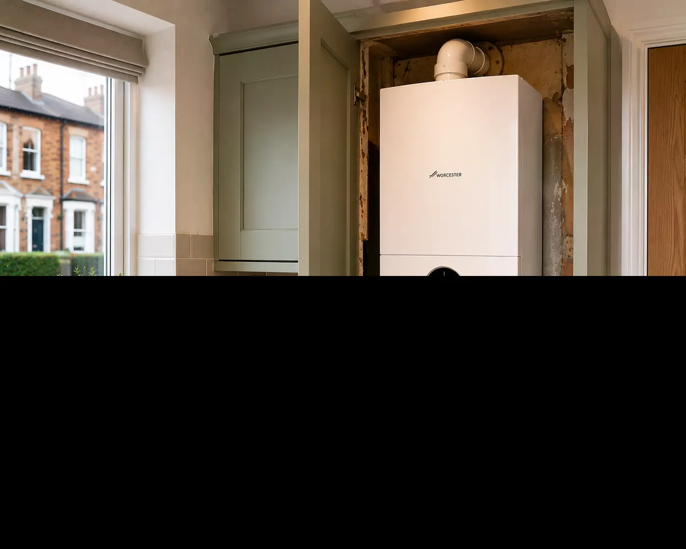Wall-mounted boiler fitted in a kitchen alcove