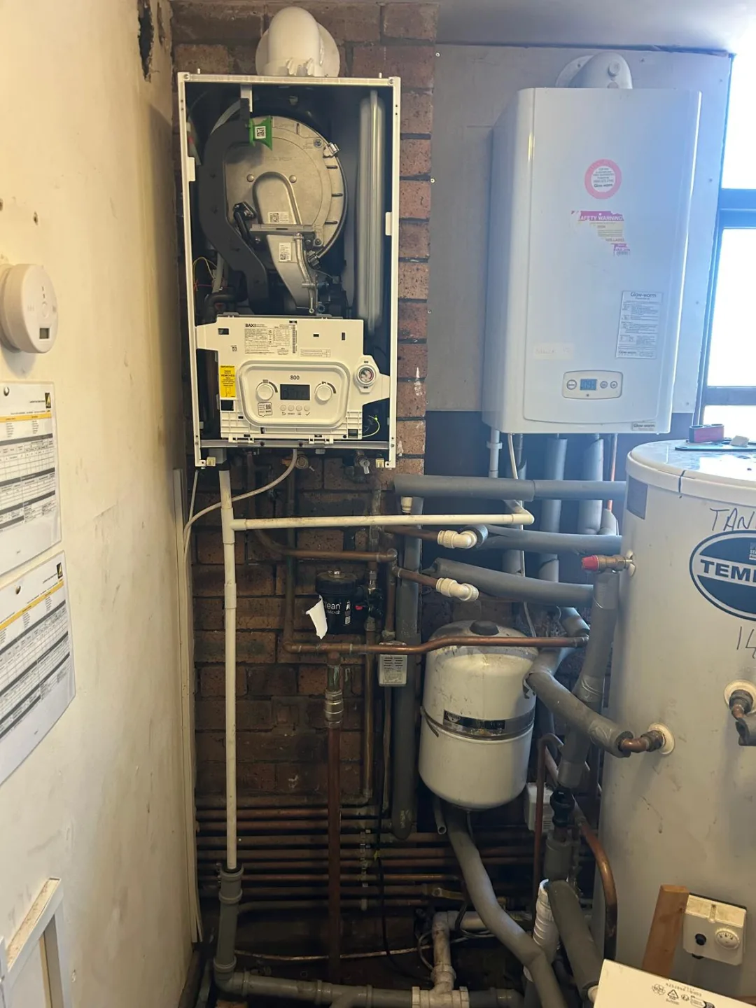 Plant area with an open gas meter cabinet, boiler, cylinder and pipework