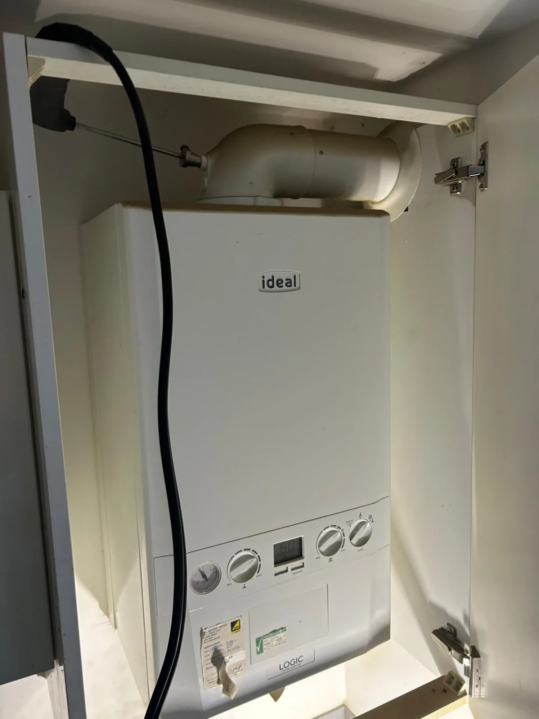 Ideal boiler inside a fitted cupboard with its flue running up through the ceiling