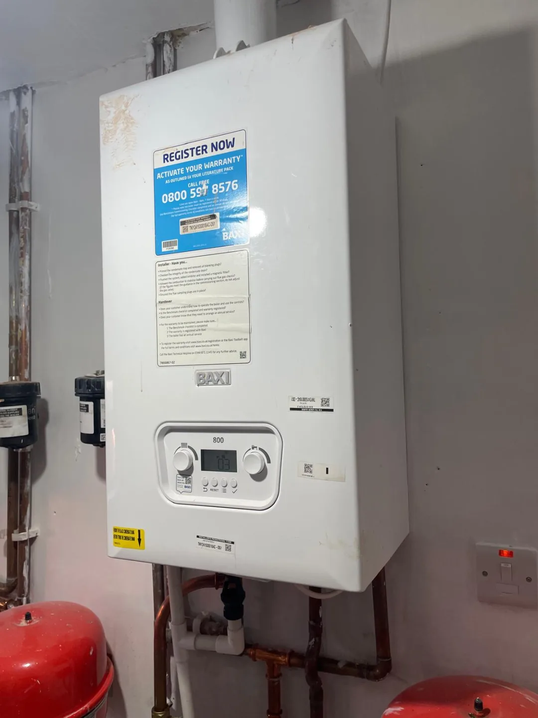 Baxi boiler with expansion vessels and pipework below it in a plant cupboard