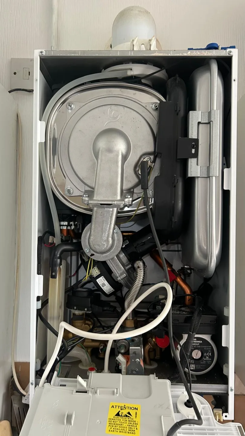 Boiler opened for servicing with the fan and heat exchanger exposed and the casing set aside