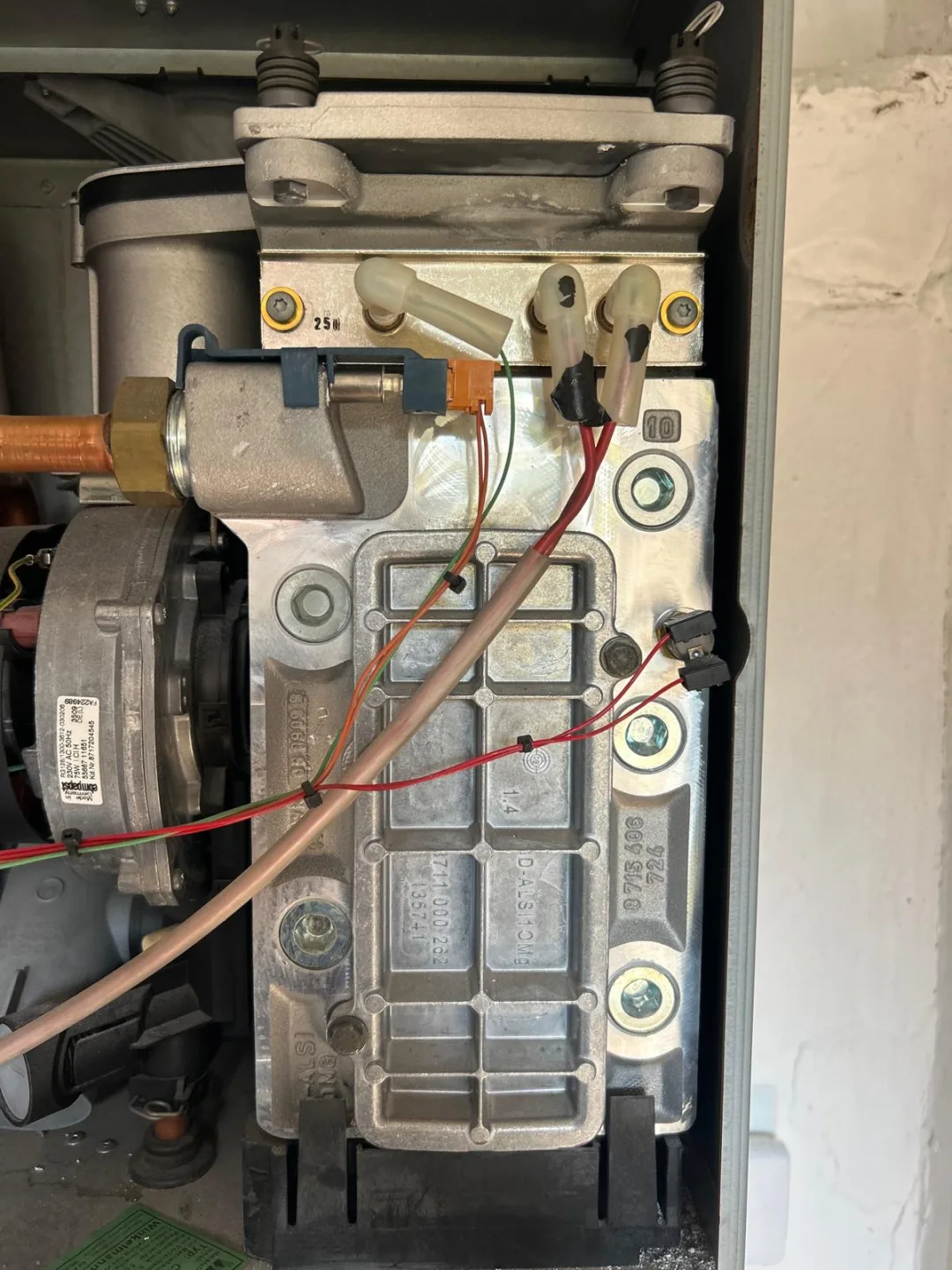 Burner and heat exchanger inside an opened boiler, wiring and gas pipe visible