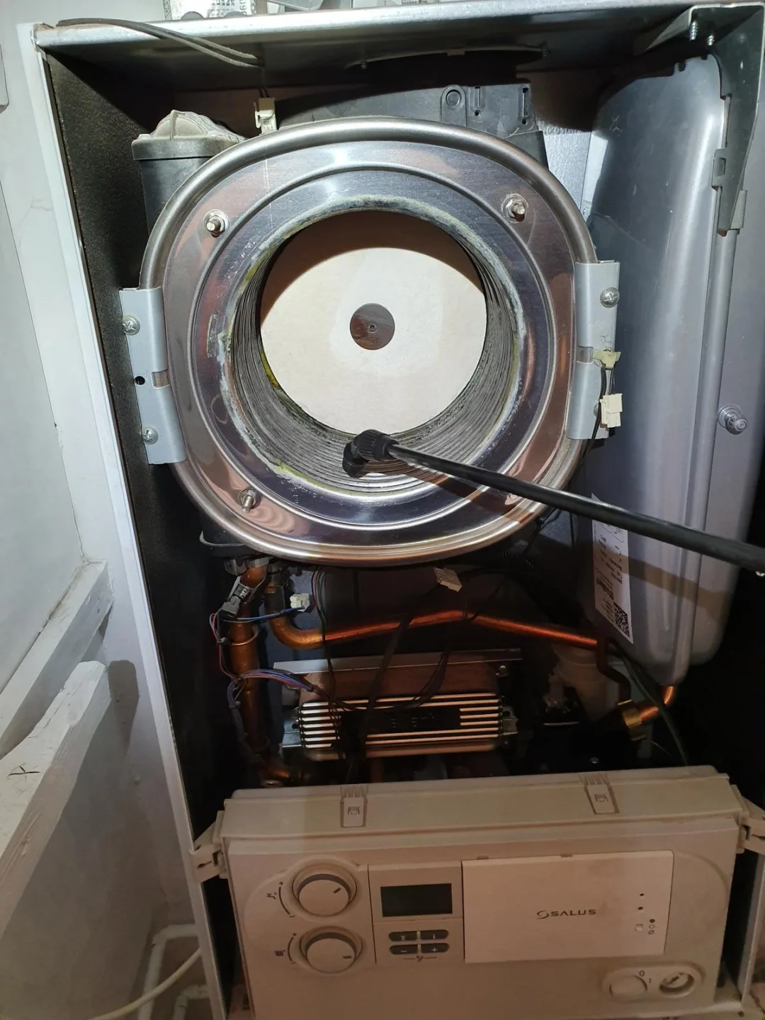 Opened boiler with the combustion chamber cover exposed during a strip-down service
