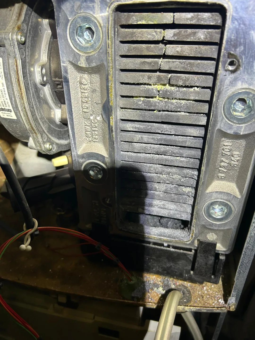 Close-up of a boiler heat exchanger and burner assembly removed for cleaning