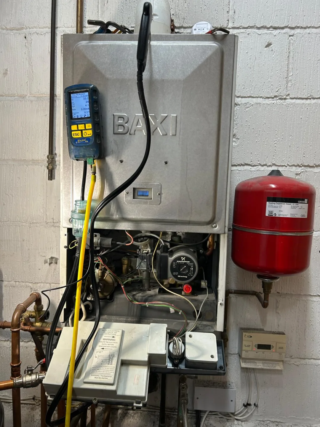 Baxi boiler opened up with the analyser connected, red expansion vessel alongside