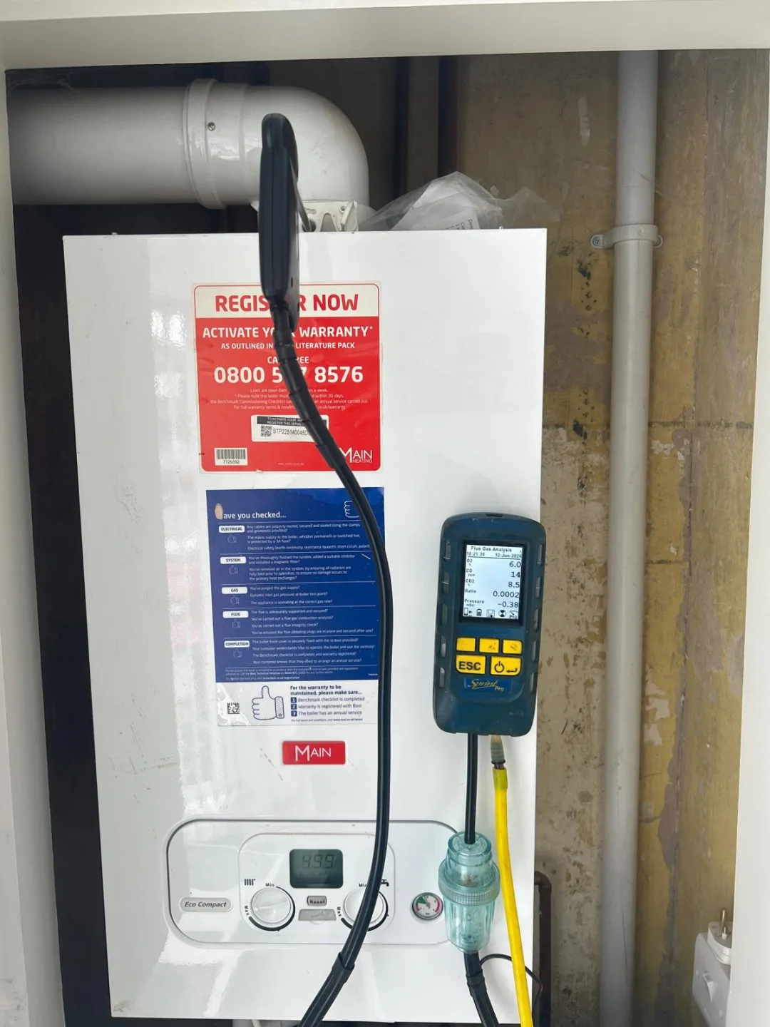 Analyser reading a boiler's combustion with the flue pipe running overhead