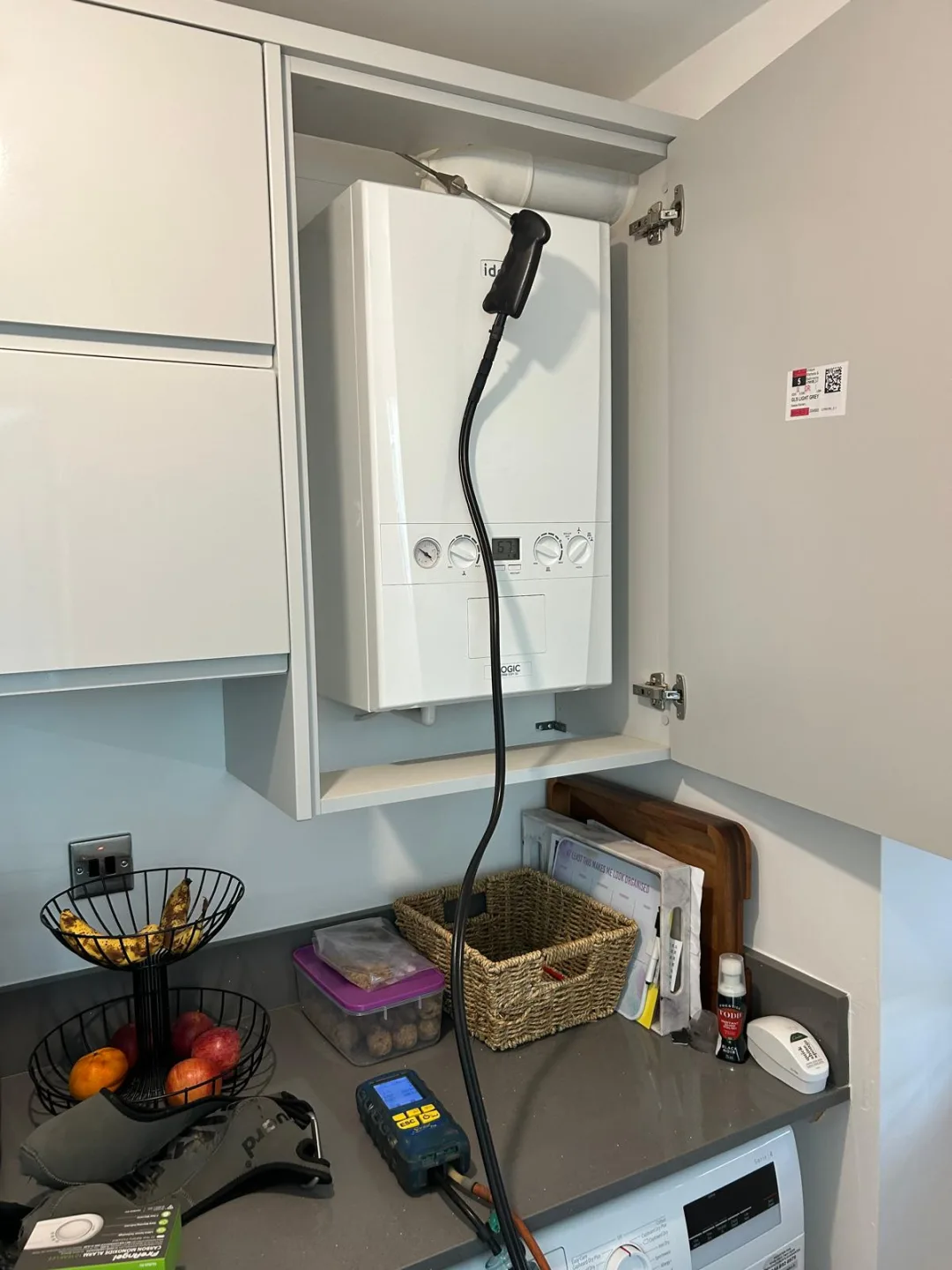 Boiler in a kitchen wall cabinet with the analyser resting on the worktop during testing
