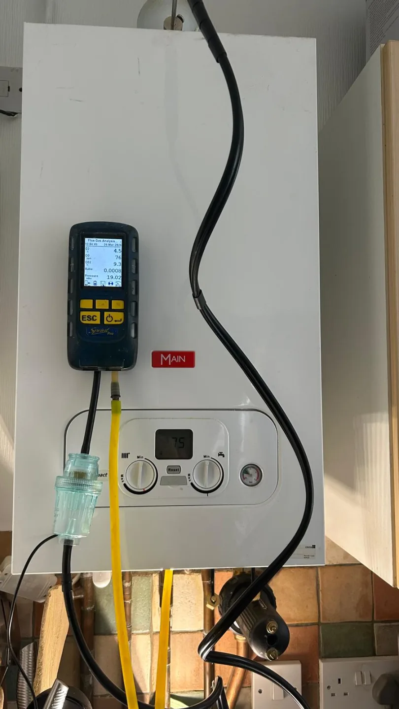 Main combi boiler being tested with the analyser and yellow sampling hose fitted