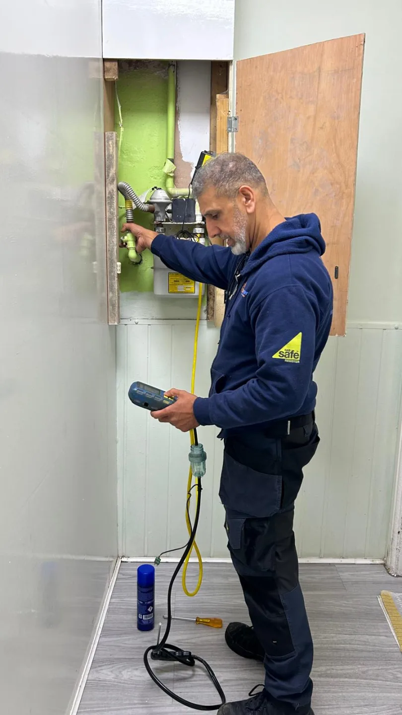 Gas Safe engineer carrying out a gas tightness test at a meter cupboard