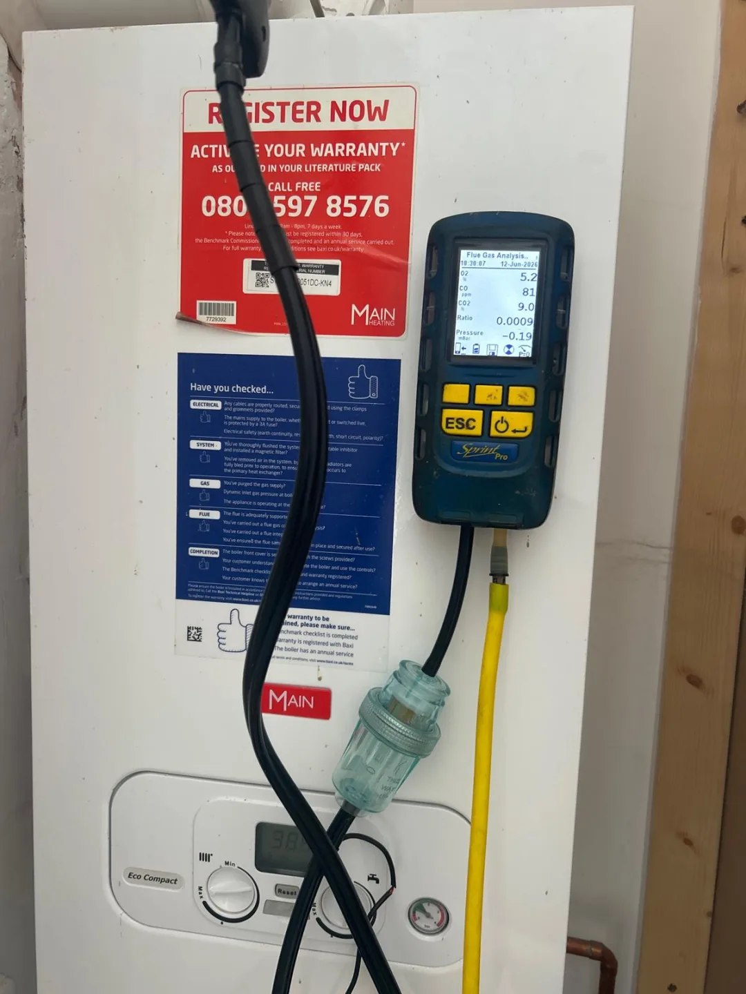 Analyser in use on a Main boiler next to its warranty registration leaflet