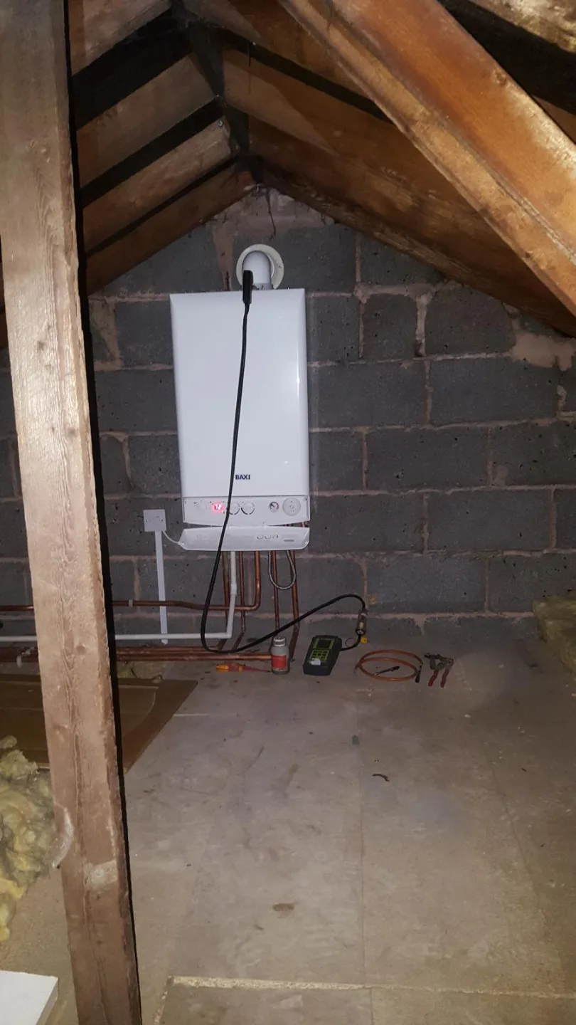 Boiler installed in a loft space with exposed roof timbers and brickwork